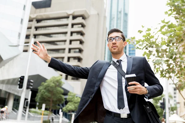 Young businessman hailing for a taxi — Stock Photo, Image