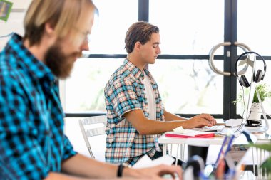 Genç adam ofiste çalışıyor.