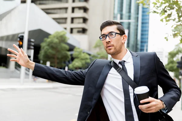 Giovane uomo d'affari in cerca di un taxi — Foto Stock