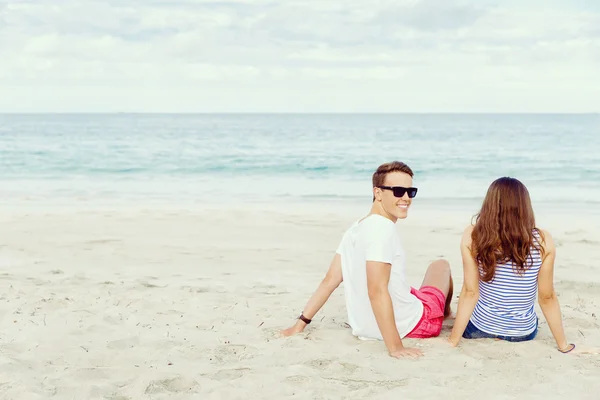 Romantico giovane coppia seduta sulla spiaggia — Foto Stock