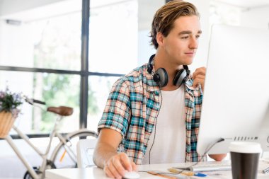 Genç adam ofiste çalışıyor.