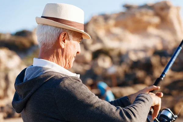 Senior mannen fiske till sjöss sida — Stockfoto