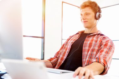 Genç adam ofiste çalışıyor.