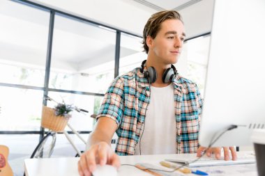 Genç adam ofiste çalışıyor.