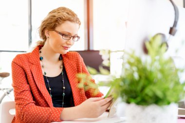 Ofiste bir fotoğraf çerçevesi tutan genç kadın