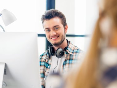 Genç adam ofiste çalışıyor.