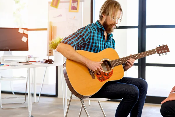 Homem tocando guitarra no escritório — Fotografia de Stock