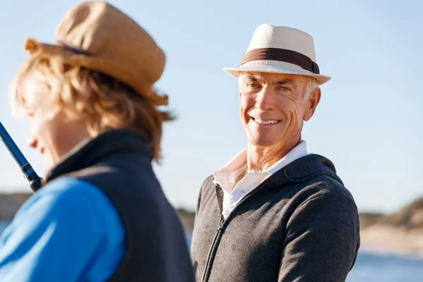 Senior man fishing with his grandson to fish at sea — Stock Photo, Image