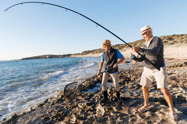 Uomo anziano pesca con suo nipote — Foto Stock