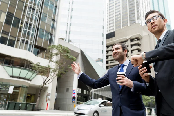 タクシーを呼ぶ 2 人の若いビジネスマン — ストック写真