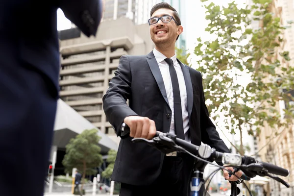 Twee jonge ondernemers met een fiets in het centrum van de stad — Stockfoto