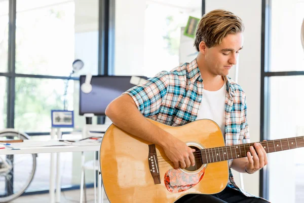 Homme jouant de la guitare au bureau — Photo