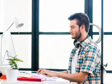 Genç adam ofiste çalışıyor.