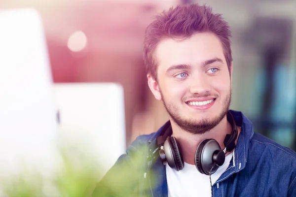 Fiatal férfi irodában mosolyogva — Stock Fotó