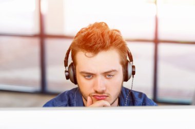 Genç adam ofiste çalışıyor.