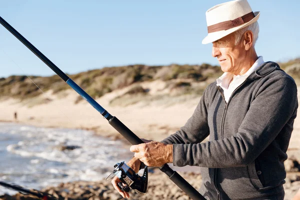 Starší muž rybolov na moři strana — Stock fotografie