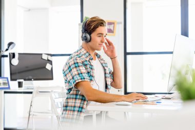 Genç adam ofiste çalışıyor.