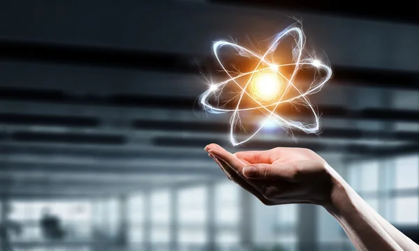 Icono de átomo en palma. Medios mixtos —  Fotos de Stock