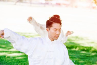 Yakışıklı adam Thai Chi yapıyor.