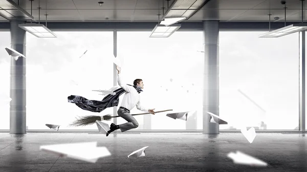 Ο άνθρωπος πετούν σκούπα στο γραφείο. Μικτή τεχνική — Φωτογραφία Αρχείου