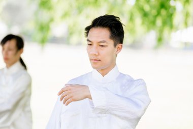 Yakışıklı adam Thai Chi yapıyor.