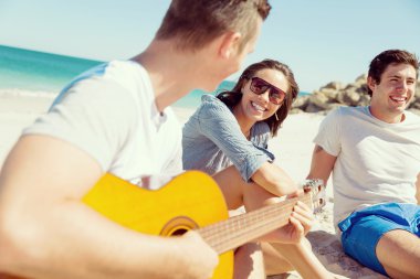 Sahilde gitar ile güzel gençler