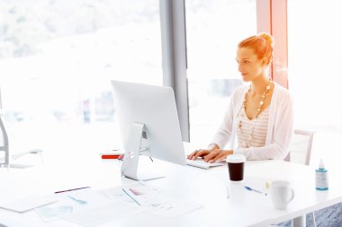 Çekici ofis çalışanı masada oturuyor.