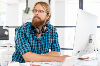 Genç adam ofiste çalışıyor.