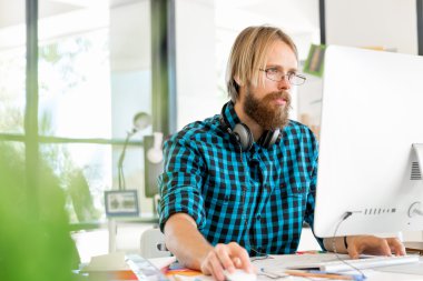 Genç adam ofiste çalışıyor.