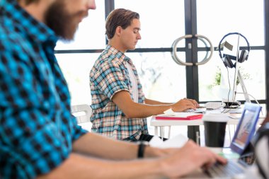 Genç adam ofiste çalışıyor.