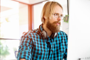 Genç adam ofiste çalışıyor.