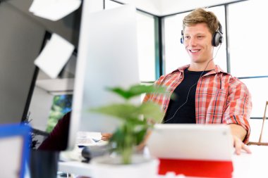 Genç adam ofiste çalışıyor.