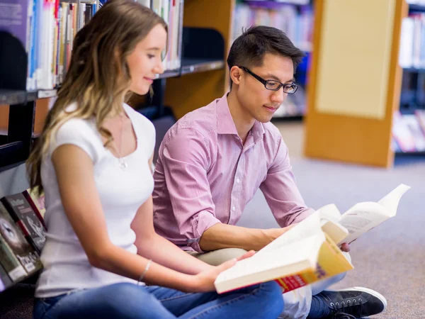 Dos jóvenes estudiantes en la biblioteca —  Fotos de Stock