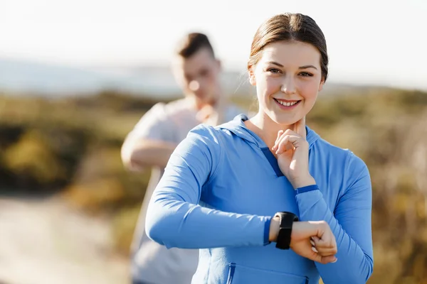 Runner woman with heart rate monitor running on beach — Stock Photo, Image