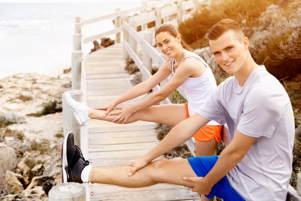 Lopers. Jong koppel uit te oefenen en stertching op strand — Stockfoto