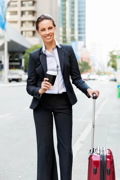 Mujer de negocios tirando de la maleta caminando en la ciudad —  Fotos de Stock