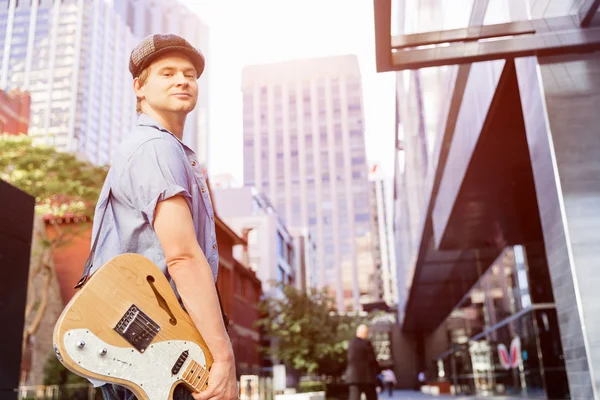 Young musician with guitar in city — Stock Photo, Image