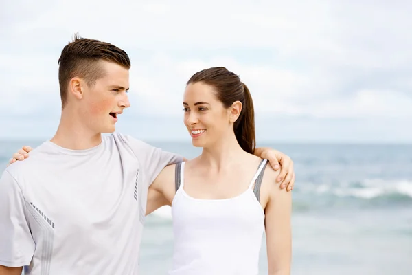 Young couple looking at each other on beach — Stock Photo, Image