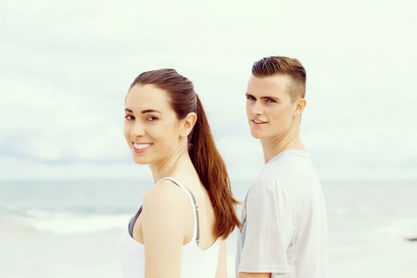 Jeune couple regardant réfléchi tout en se tenant à côté de l'autre sur la plage — Photo