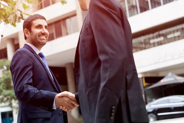 Dos hombres de negocios estrechando sus manos — Foto de Stock