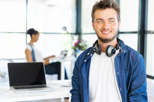 Young man sitting and looking at camera in office — Stock Photo, Image