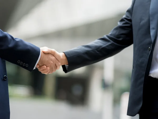 Dos hombres de negocios estrechando sus manos — Foto de Stock