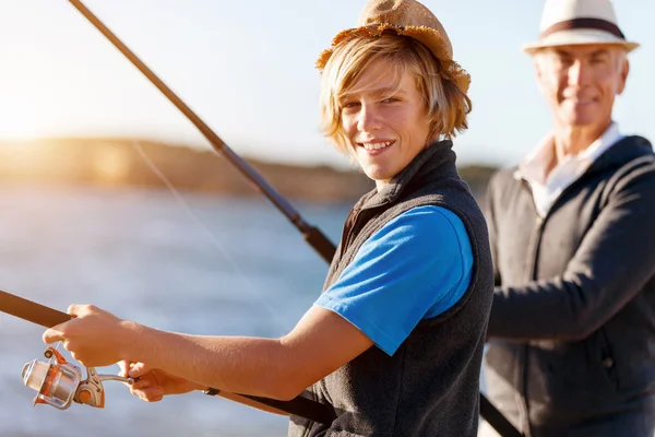 Senior man vissen met zijn kleinzoon — Stockfoto