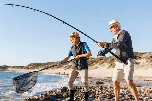 Hombre mayor pescando con su nieto —  Fotos de Stock