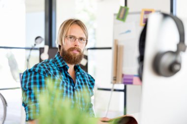 Genç adam ofiste çalışıyor.