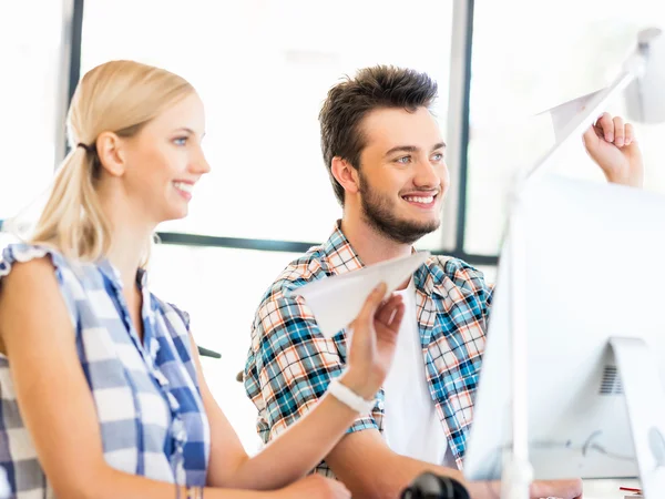 Twee medewerkers aan de balie met papier vliegtuigen — Stockfoto