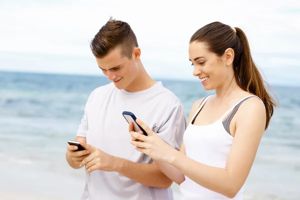 Пара бегунов с мобильными смартфонами на улице — стоковое фото