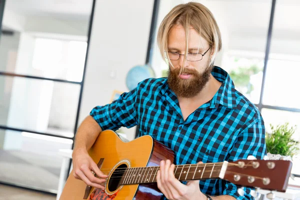 Homem tocando guitarra no escritório — Fotografia de Stock