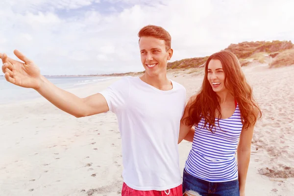 Glückliches junges Paar beim gemeinsamen Spaziergang am Strand — Stockfoto