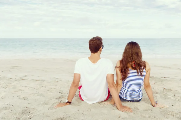 Romantique jeune couple assis sur la plage — Photo